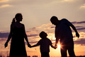 Happy family standing in the park at the sunset time. - PhotoDune Item for Sale