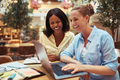 Diverse businesswomen laughing while working on a laptop - PhotoDune Item for Sale