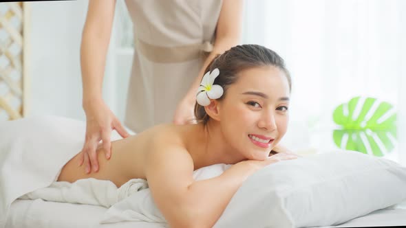 Portrait of Asian young woman feeling happy and relax during back massage with oil.