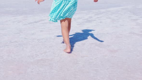 Little Faceless Girl Walks on Surface of Salt Lake