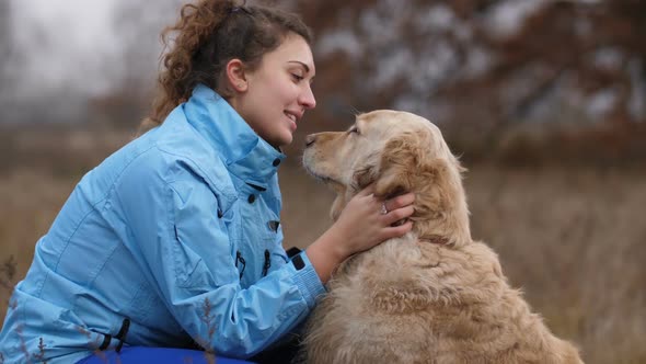 Cheerful Woman Embracing Her Cute Dog Outdoors