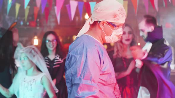 Slow Motion Shot of a Man in Psycho Mad Surgeon Costume at a Halloween Party