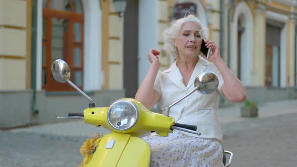 Woman on Scooter Holding Phone