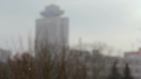 Snowfall in the City With Buildings on Blurred Background.