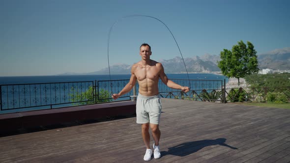 Slow Motion Shot of a Man Having Cardio Training Outdoors and Throwing Skipping Rope When Finishing