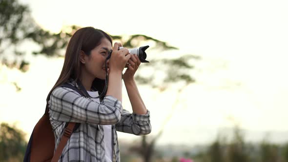 tourist woman taking a photo with her camera in nature