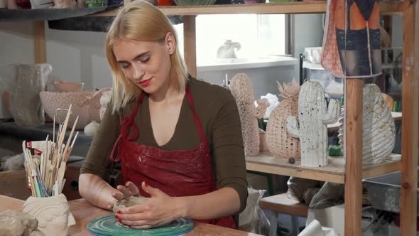 Gorgeous Young Woman Smiling While Working with Clay at the Workshop