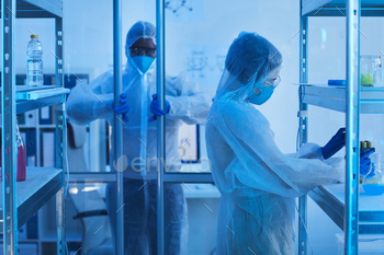 ar entering laboratory room, his female colleague taking test-tubes off shelf