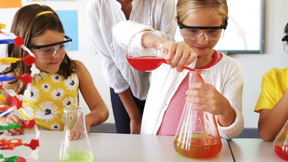 School kids doing a chemical experiment in laboratory