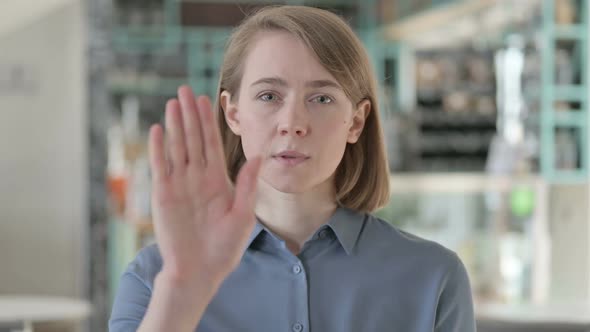 Portrait of Young Woman Showing Stop Sign By Hand