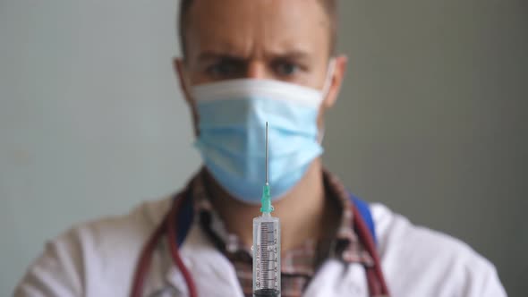 Portrait of Doctor in Protective Mask Pouring Liquid From Syringe and Tapping on It