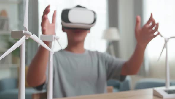 Blur Boy Wearing VR Glasses While Experimenting With Wind Turbine Model At Home