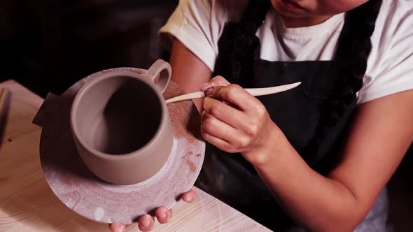 Pottery in the Art Studio Woman Holding a Cup on the Plate and Smearing Clay on the Joint on the