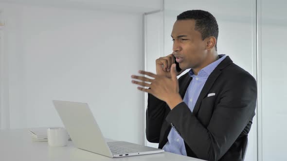 Angry Casual AfroAmerican Businessman Yelling During Phone Talk Negotiating