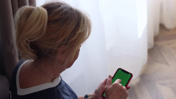 Portrait of Senior Woman Touching Smartphone Green Chromakey Screen