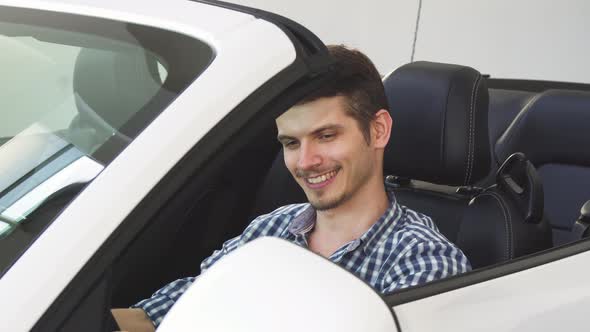 Handsome Happy Young Male Driver Holding Car Keys Sitting in His Auto