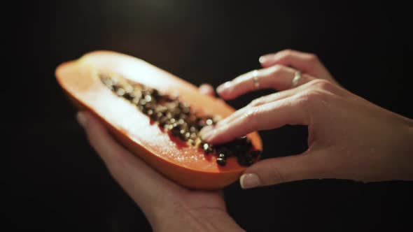 Female hands hold fresh juicy papaya cut in half