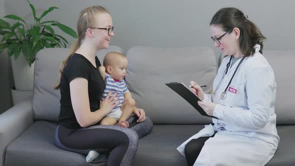 Pediatrician Woman Uniform Doing Check Up Baby Mother Home Clipboard Make Notes