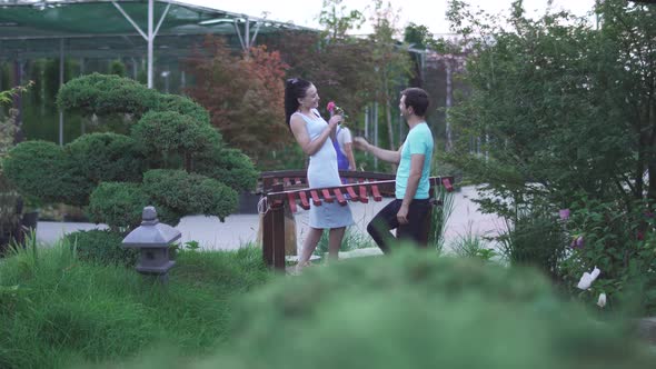 Adult Man Gives Flower To Lady in the Garden