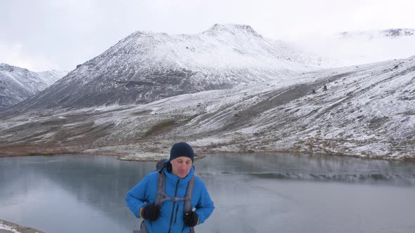 A Man with a Backpack Climbs Into the Mountains