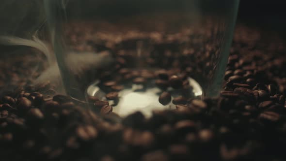 Fragrant Roasted Coffee Beans Are Splashing at the Glass. Aromatic Smoke and Brown Background in