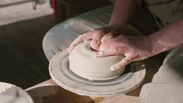 Potter Is Modeling Vessel of Wet Clay On Rotating Disk