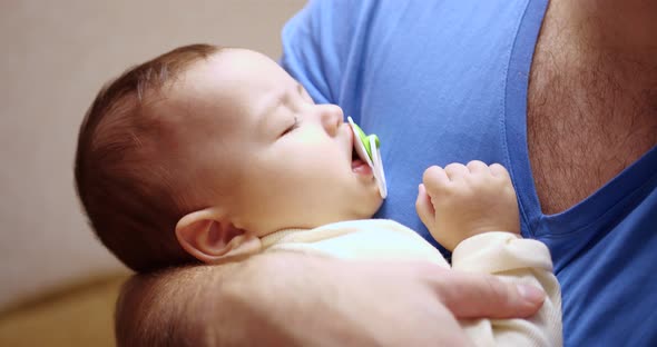 a Small Child Fell Asleep in His Father's Arms