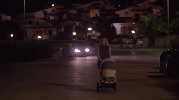 Mother with baby having late walk in the street