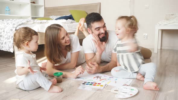 Cheerful Couple and Their Adorable Daughter Paiting in Watercolours