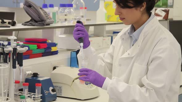 Female Scientist in science laboratory and looks at screen with stem cells