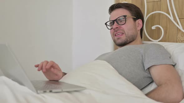 Beard Young Man Having Back Pain on Laptop in Bed