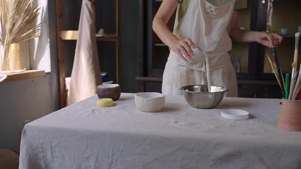 Female Potter Making Glaze for Ceramic Bowl