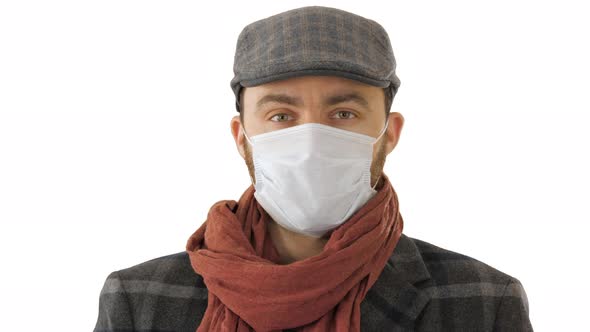 Handsome Young European Man in Trendy Coat Wearing Disposable Protective Face Mask on White