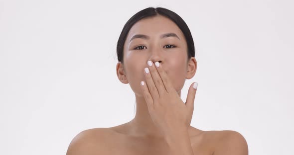 Young Asian Woman Sending Blow Kiss To Camera Posing Over White Studio Background Slow Motion