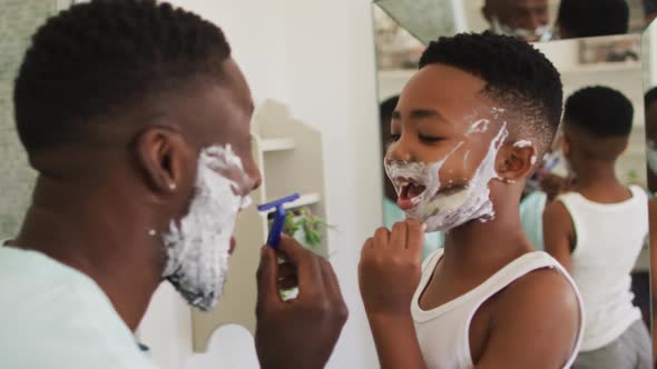 African american father and son shaving together