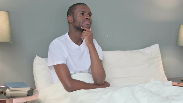 Pensive Young African Man Thinking in Bed 