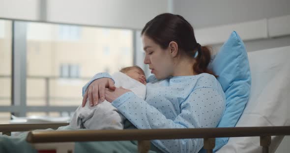Mother with Newborn Baby in Postnatal Department Ward
