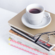 Stack of different books and notepads with woman&#39;s glasses and coffee cup on the top on a white - photodune.net Item for Sale