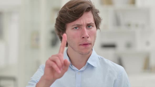 Portrait of Young Businessman Saying No with Finger Sign