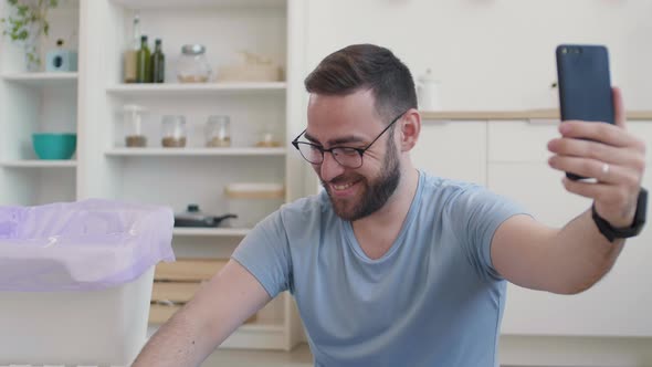 Man Doing Garbage Segregation while Having Video Call