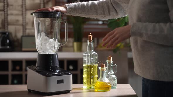 Woman is Crushing Ice in Blender in the Kitchen