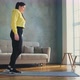 Woman in Yellow Hoodie Does Dynamic Lunges at Home - VideoHive Item for Sale