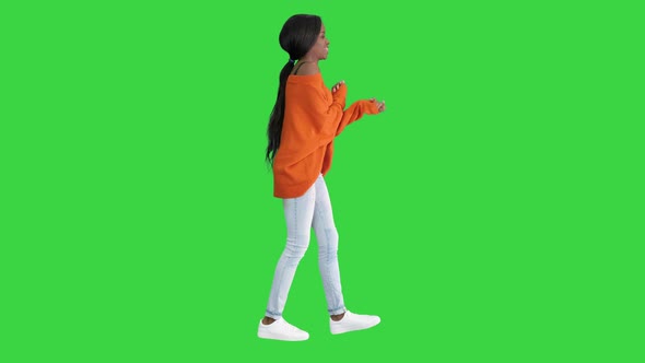 Young Casual African Woman Dancing on a Green Screen, Chroma Key.