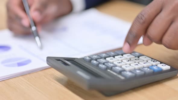 African Businessman Using Calculator for Financial Work