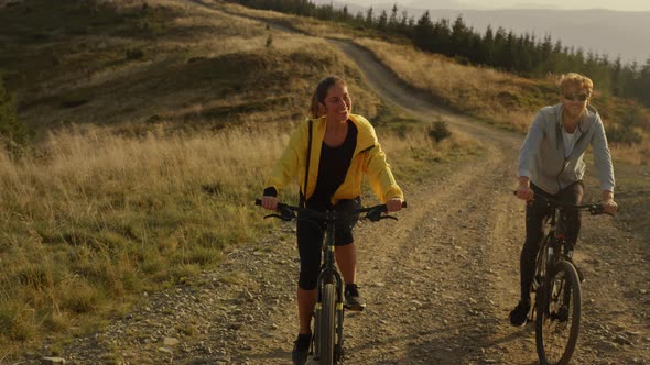 Woman and Man Cycling on Mountain Road