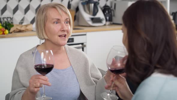 Video of two generation women drinking wine at home. Shot with RED helium camera in 8K.