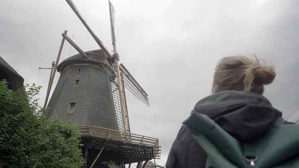 Tourism in the Netherlands - A Young Woman Admires an Old Windmill.