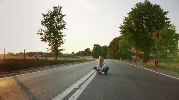 Young Woman Taking Selfie on Road. Lovely Young Lady Smiling and Posing for Selfie While Sitting on