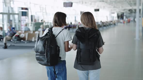 Happy Couple of Lesbians Walking and Chatting at Airport