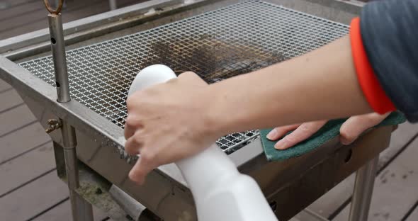 Woman wash the BBQ oven